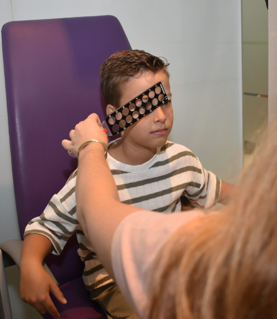 Revisión visual para niños Optometrista realizando una revisión visual a un paciente